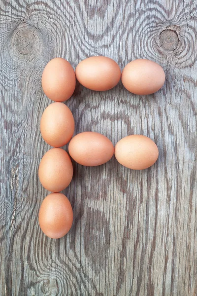 Een brief f van de eieren voor Pasen. op een houten textuur. — Stockfoto