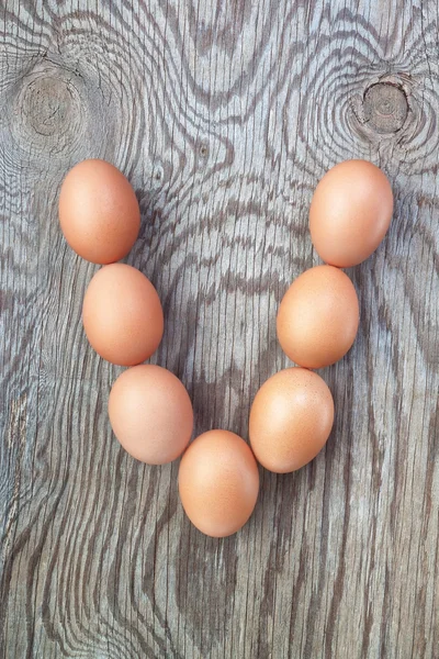 Een brief v van de eieren voor Pasen. op een houten textuur. — Stockfoto