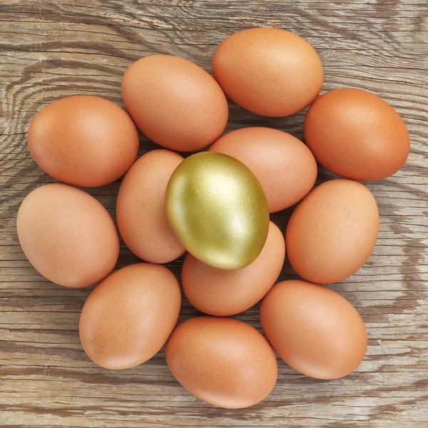 Gruppe von Eiern und einem goldenen. zu Ostern. auf einem hölzernen Textur. — Stockfoto