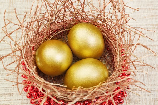 Guld ägg i boet och pärlor. koncept för påsk. — Stockfoto