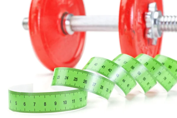 Green measuring meter and dumbbells for fitness. On a white back — Stock Photo, Image