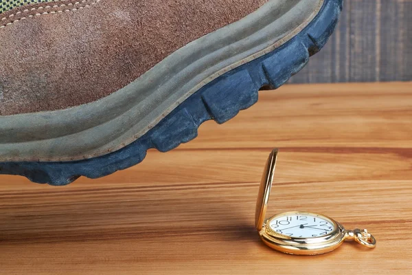 Metáfora-matando el tiempo. botas en el reloj de oro. —  Fotos de Stock