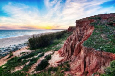 Deniz ve dağ yamaçları ile güzel bir gün batımı.