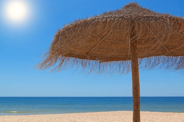 Wooden straw umbrella for the sun on the beach near the sea. — Stock Photo, Image