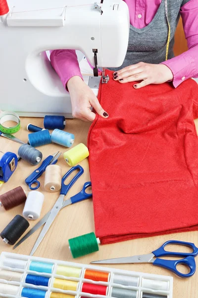 Mujer cose en el desgaste de las piezas de la máquina de coser. —  Fotos de Stock