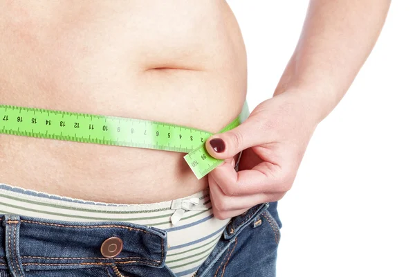 Fat woman sewing meter measures the waist abdomen. On a white ba — Stock Photo, Image