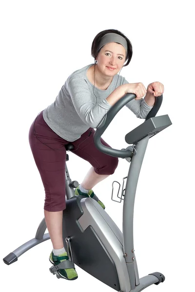 Vrouw, middelbare leeftijd op een upright bike oefenen voor afslanken. — Stockfoto