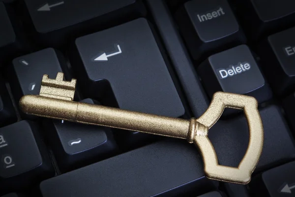 Golden key on the keyboard symbol of safety and protection. — Stock Photo, Image