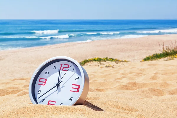 Klassiska analoga klockor i sanden på stranden nära havet. för — Stockfoto