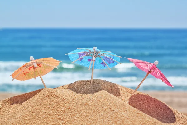 Pequeñas sombrillas en la playa en un fondo del mar. —  Fotos de Stock