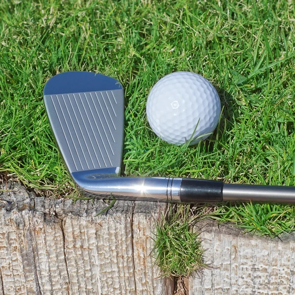 Golf stick and ball support wooden close-up on the grass. — Stock Photo, Image