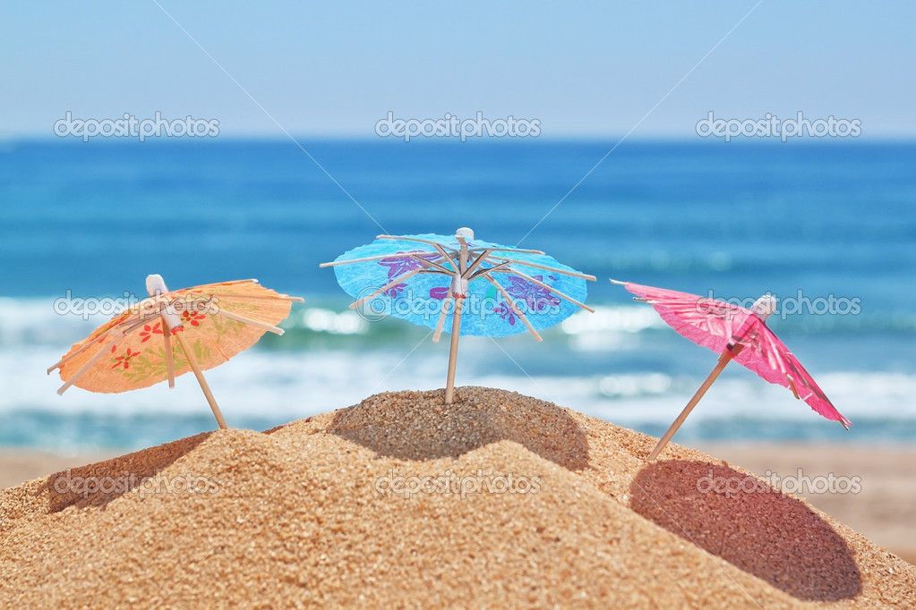 Small beach umbrellas on a beach on a background of the sea. Stock