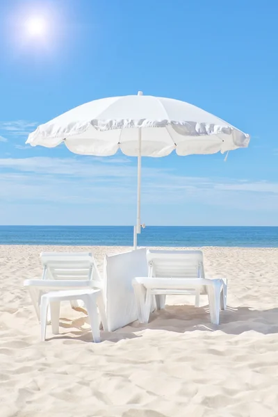 Beautiful white beach umbrella and sun bed on a sunny beach. For — Stock Photo, Image