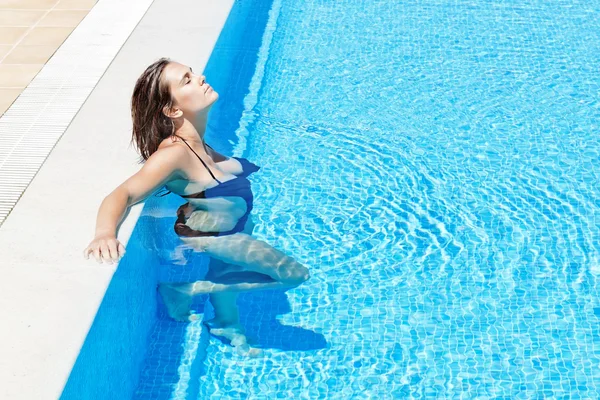 Jovem e bela garota relaxa na piscina. no verão outs — Fotografia de Stock