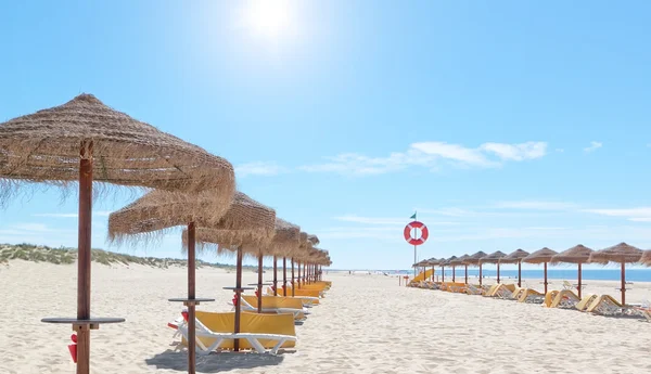 美丽的阳光海滩在葡萄牙与海滩遮阳伞和太阳 b — 图库照片