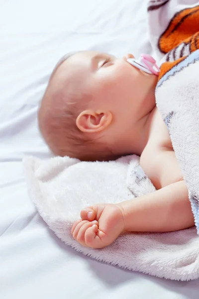 Covered with a sleeping baby with a pacifier. Close-up. - Stock-foto