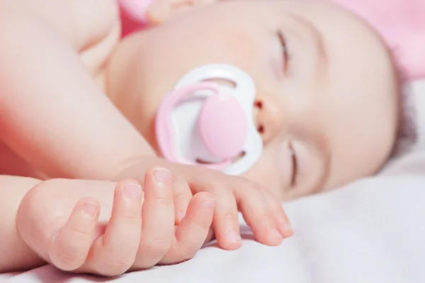 Cute baby asleep in bed, hands in focus in the foreground. Close — Stock Photo, Image