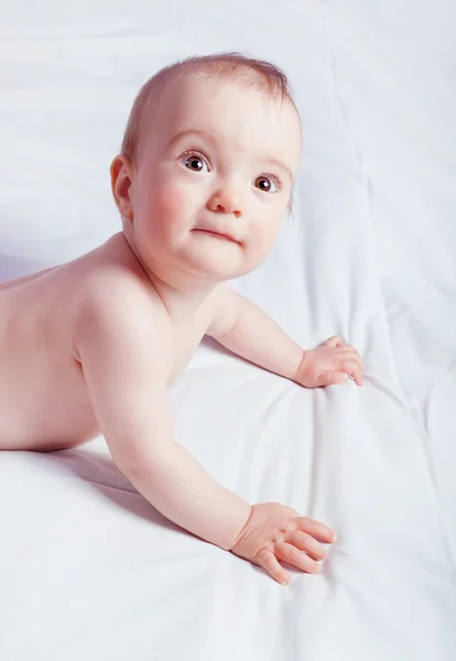 Cute curious baby girl lying down and looking up. Close-up. — Stock Photo, Image
