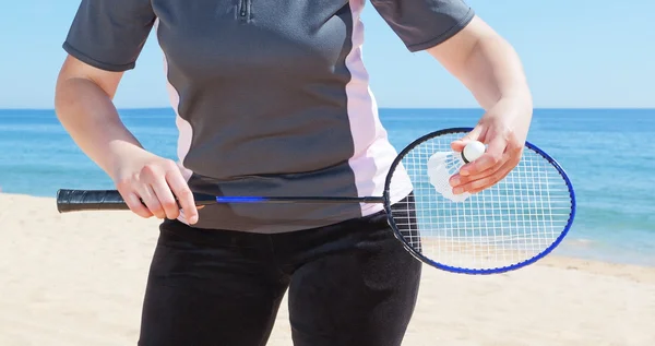 A girl plays badminton on the beach. Close-up. — Stock Photo, Image