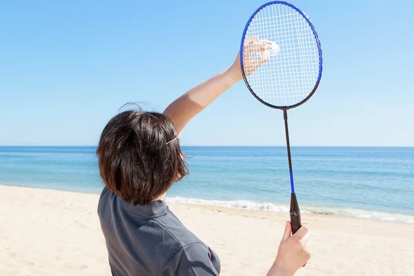 Dívka na pláži podává hrát badminton. detail. — Stock fotografie