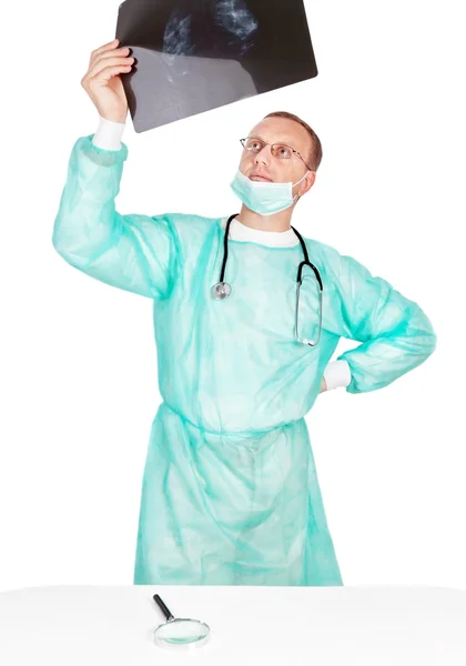 Jovem macho médico examina um raio-x com uma lupa. CLO — Fotografia de Stock
