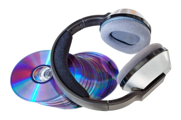 Modern wireless headphones on a pile of CDs and DVDs. On a white — Stock Photo, Image