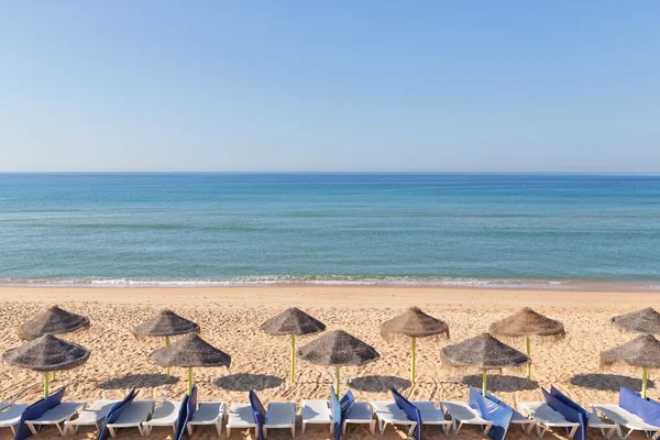 Exotická krajina s slunečníky na pláži nedaleko pláže. v — Stock fotografie