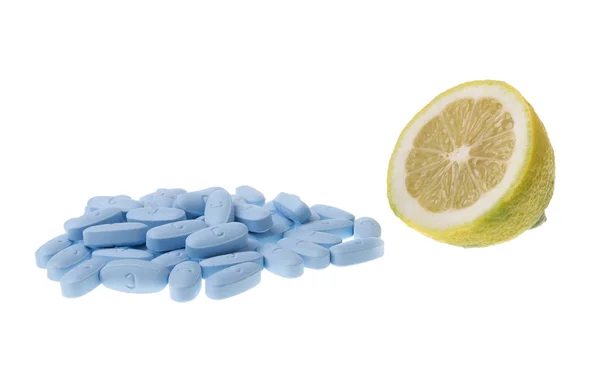 Tablets Vitamins and lemon fruit comparison is better for your health. On a white background. — Stock Photo, Image
