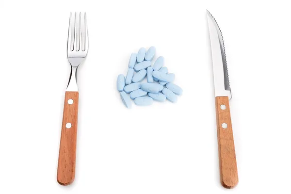 Concept preparation to eating pills with a knife and fork. On a white background. — Stock Photo, Image