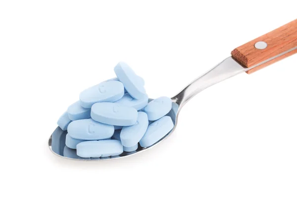Group of pills on a spoon for dosing. On a white background. — Stock Photo, Image