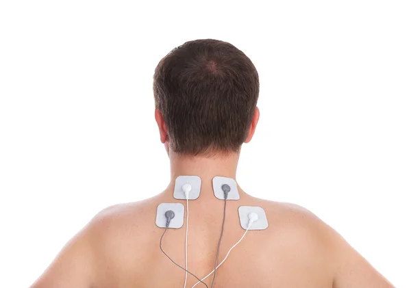 Hombre con problemas en el cuello y en el masaje de la columna vertebral hace electroestimulador. — Foto de Stock