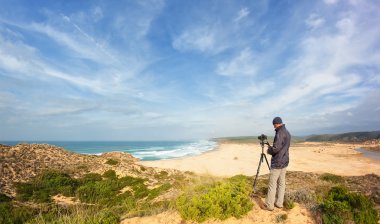 erkek seyahat fotoğrafçı ve dunes içinde fotoğraf. tripod ve kamera ile.