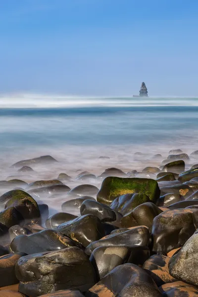 Mořské kameny v popředí v krajině u moře. Portugalsko, aljezur. — Stock fotografie