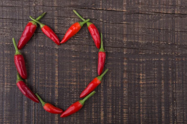 Paprika rode peper in de vorm van hart. de textuur op een houten achtergrond. Aftelkalender voor Valentijnsdag. — Stockfoto