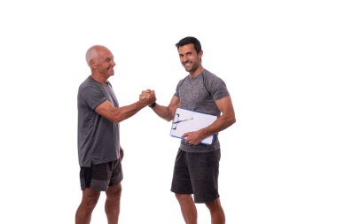 Yaşlı adam kişisel fitness eğitmeniyle el sıkışıyor, birlikte çalışma kavramı. Beyaz arkaplanda.