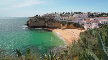 Portekiz Carvoeiro sahilinin açık deniz ve güneşlenen turistlerle dolu güzel bir manzarası var. Dengeleyiciyle atış..