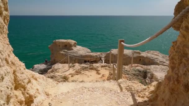 Camine por senderos de piedra de montaña y túneles a lo largo de la costa portuguesa, la zona del Algarve, Carvoeiro. — Vídeos de Stock