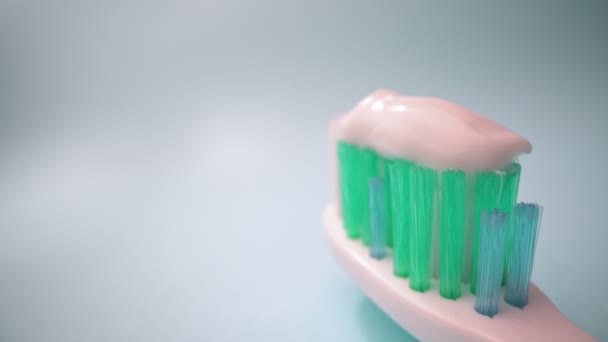 Grabación de vídeo macro extrema, cepillo de dientes sobre un fondo azul en movimiento, pasta de dientes en el cepillo. Movimiento hacia adelante, Primer plano. — Vídeos de Stock