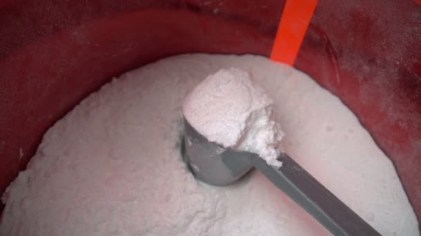 Filmando una macro extrema, alejándose de una taza medidora con polvo de bcaa de proteína blanca, glutamina, en un tanque. Vista superior. — Vídeos de Stock