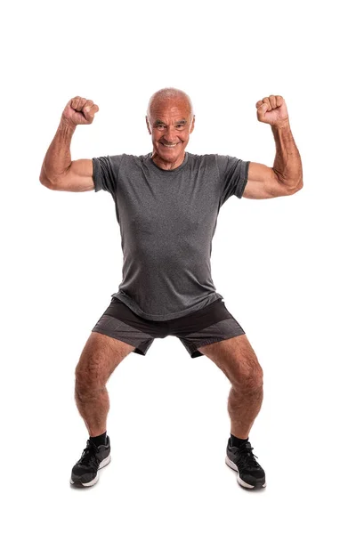 L'anziano pensionato, atleta, alzò le mani, celebrando la vittoria e il successo. Su sfondo bianco. — Foto Stock