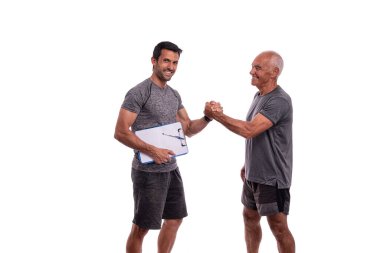 Yaşlı adam kişisel fitness eğitmeniyle el sıkışıyor, birlikte çalışma kavramı. Beyaz arkaplanda.