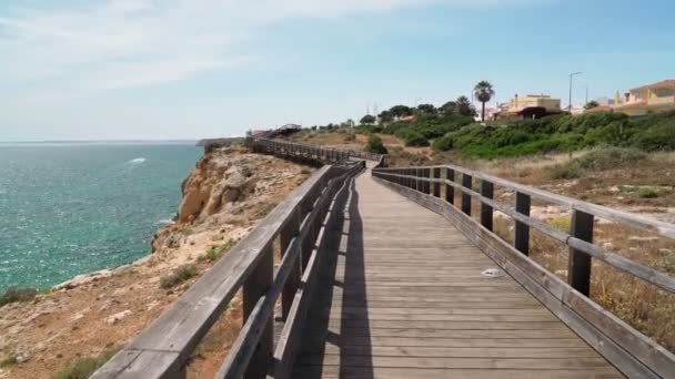 Maravilhosa vista da costa portuguesa do Carvoeiro no verão, caminhando pelos caminhos de madeira. Com vista para o mar azul. Tiro em movimento com um estabilizador. — Vídeo de Stock