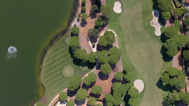 Aerial overview of Quinta do Lago resort buildings in Vale de Lobo, Algarve, Portugal, Europe. Shot of rooftops of luxury cottages in green landscape with mountains on background. Golf fields. — Stock Video