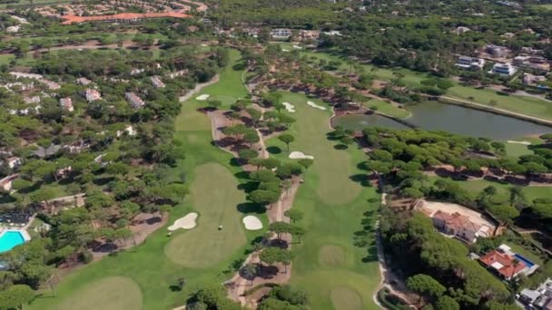 Panoramica aerea degli edifici del resort Quinta do Lago a Vale de Lobo, Algarve, Portogallo, Europa. Girato di tetti di cottage di lusso in un paesaggio verde con montagne sullo sfondo. Campi da golf. — Video Stock