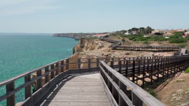 Yazın, Portekiz 'in Carvoeiro sahilinin ahşap patikalar boyunca yürüdüğü harika bir manzara. Mavi deniz manzaralı. Dengeleyiciyle atış.. — Stok video