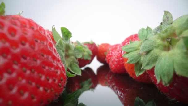 Rijpe, frisse, natuurlijke aardbeien in reflectie, in extreme macro, close-up. Voorwaarts, achterwaarts. — Stockvideo