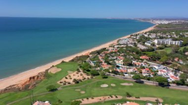 Vale de Lobo, Algarve, Portekiz, Avrupa 'daki Quinta do Lago tatil köylerinin hava manzarası. Yeşil manzaralı, arka planda dağlar olan lüks kulübelerin çatıları. Golf alanları.