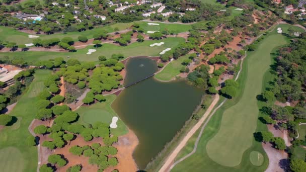Luftaufnahme der Gebäude des Quinta do Lago Resorts in Vale de Lobo, Algarve, Portugal, Europa. Aufnahme von Dächern von Luxus-Ferienhäusern in grüner Landschaft mit Bergen im Hintergrund. Golfplätze. — Stockvideo