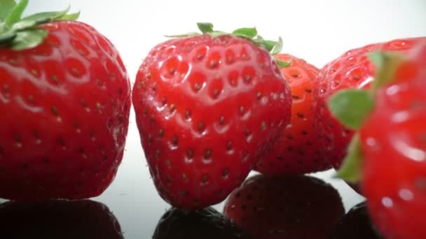 Ripe, fresh, natural strawberries in reflection, in extreme macro, close up. Movement forward, backward. — Stock Video