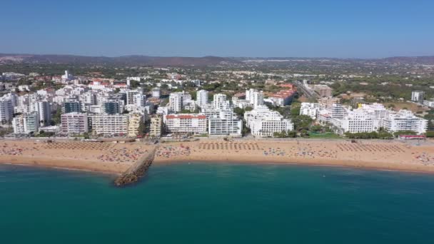 Imagens de drones, filmando a cidade turística de Quareira, nas margens do Oceano Atlântico, praias com turistas. Portugal, Algarve. — Vídeo de Stock